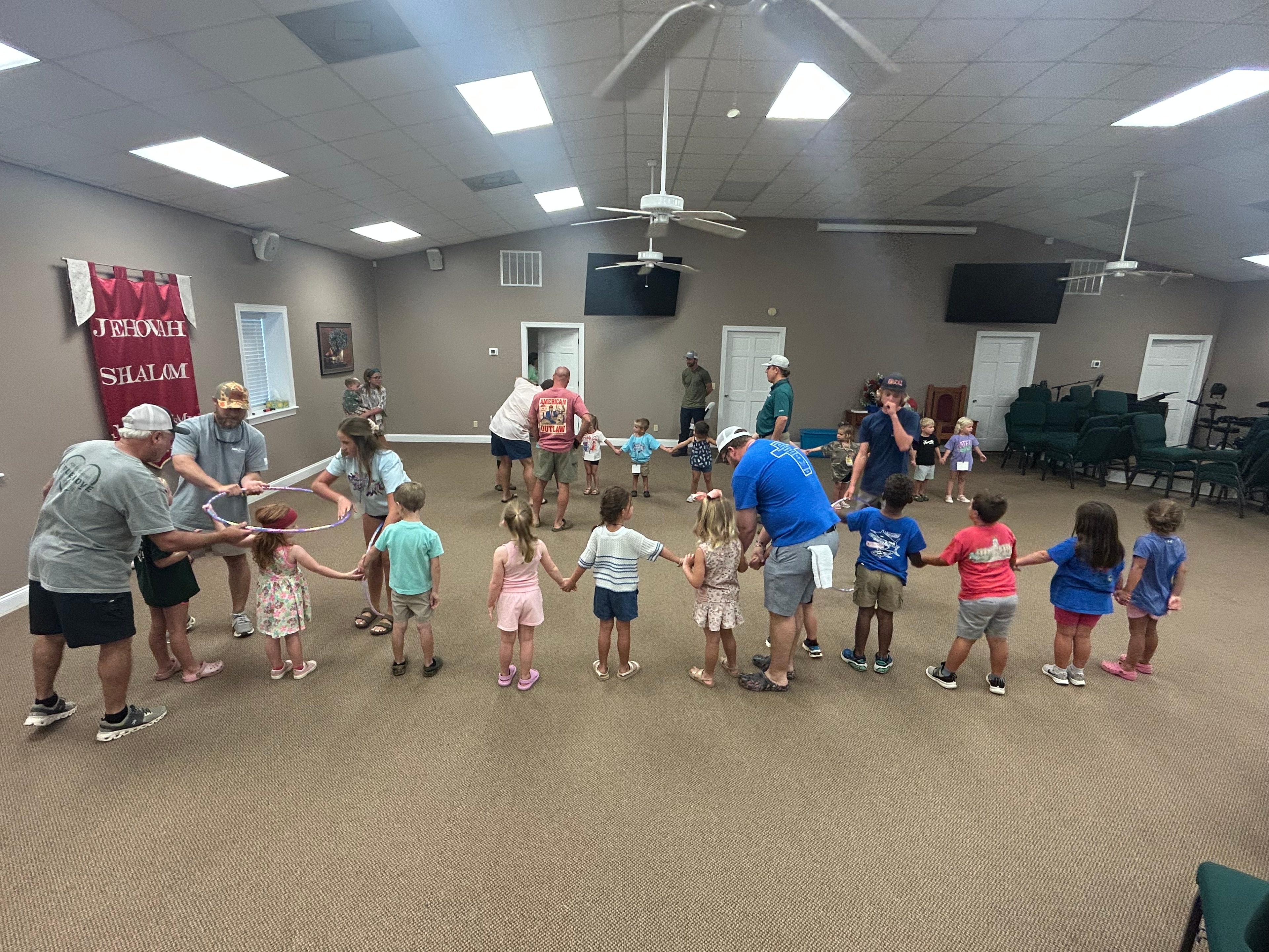 Children and adults playing a group game in the worship center during VBS 2026