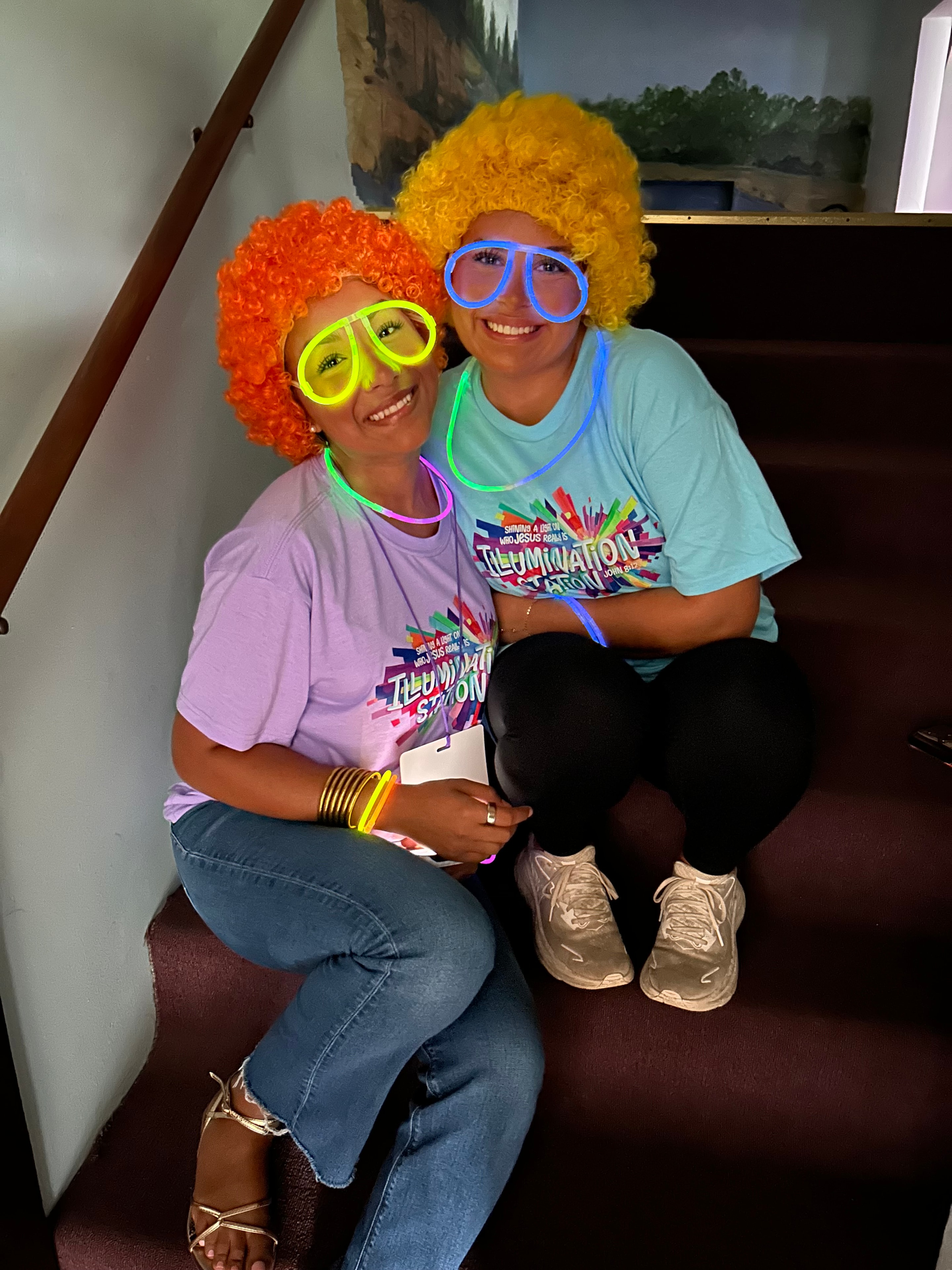 Two VBS participants in colorful wigs and glow glasses at VBS 2026