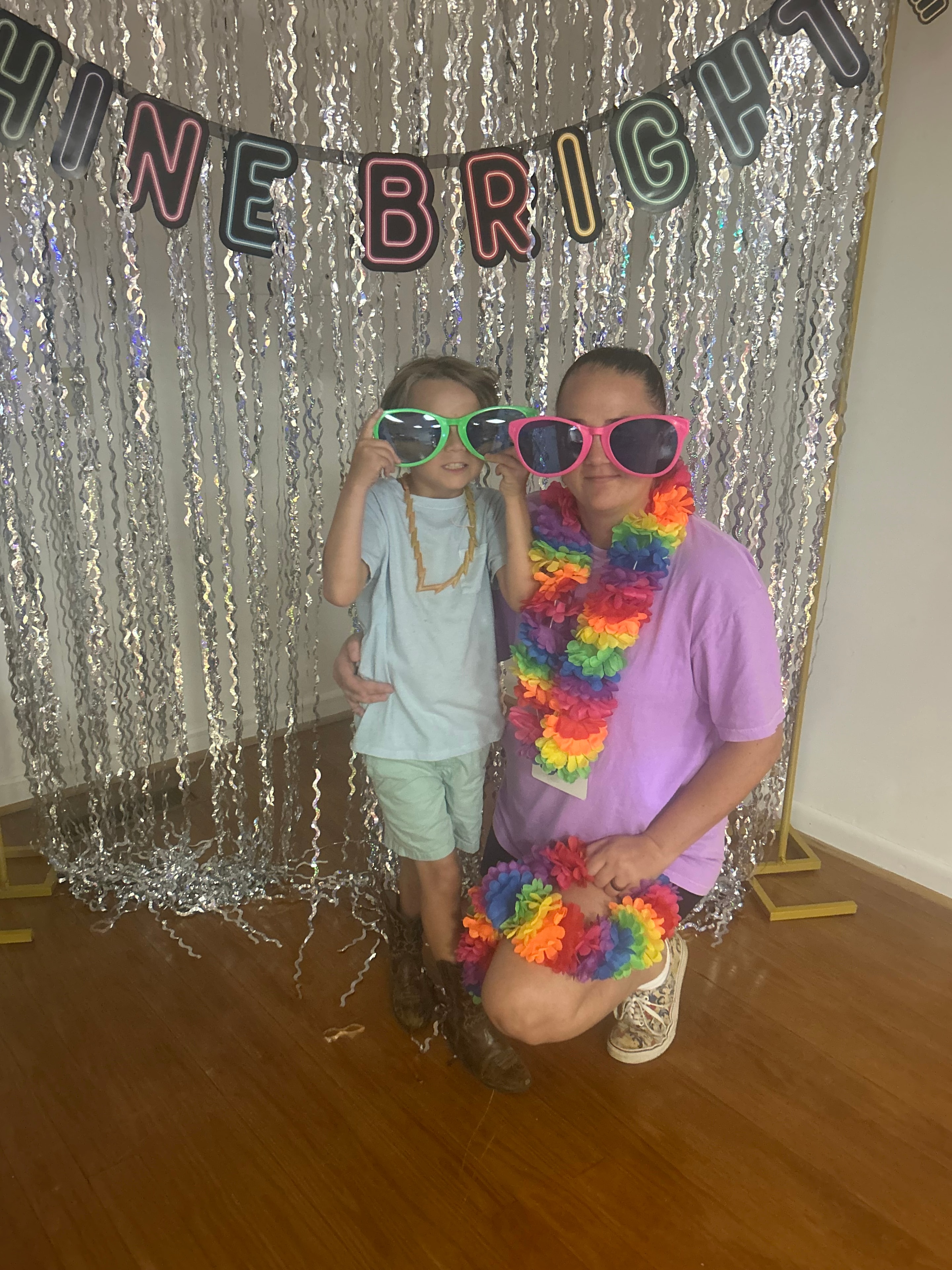 Two children posing at the VBS 2026 photo booth with rainbow lei and sunglasses