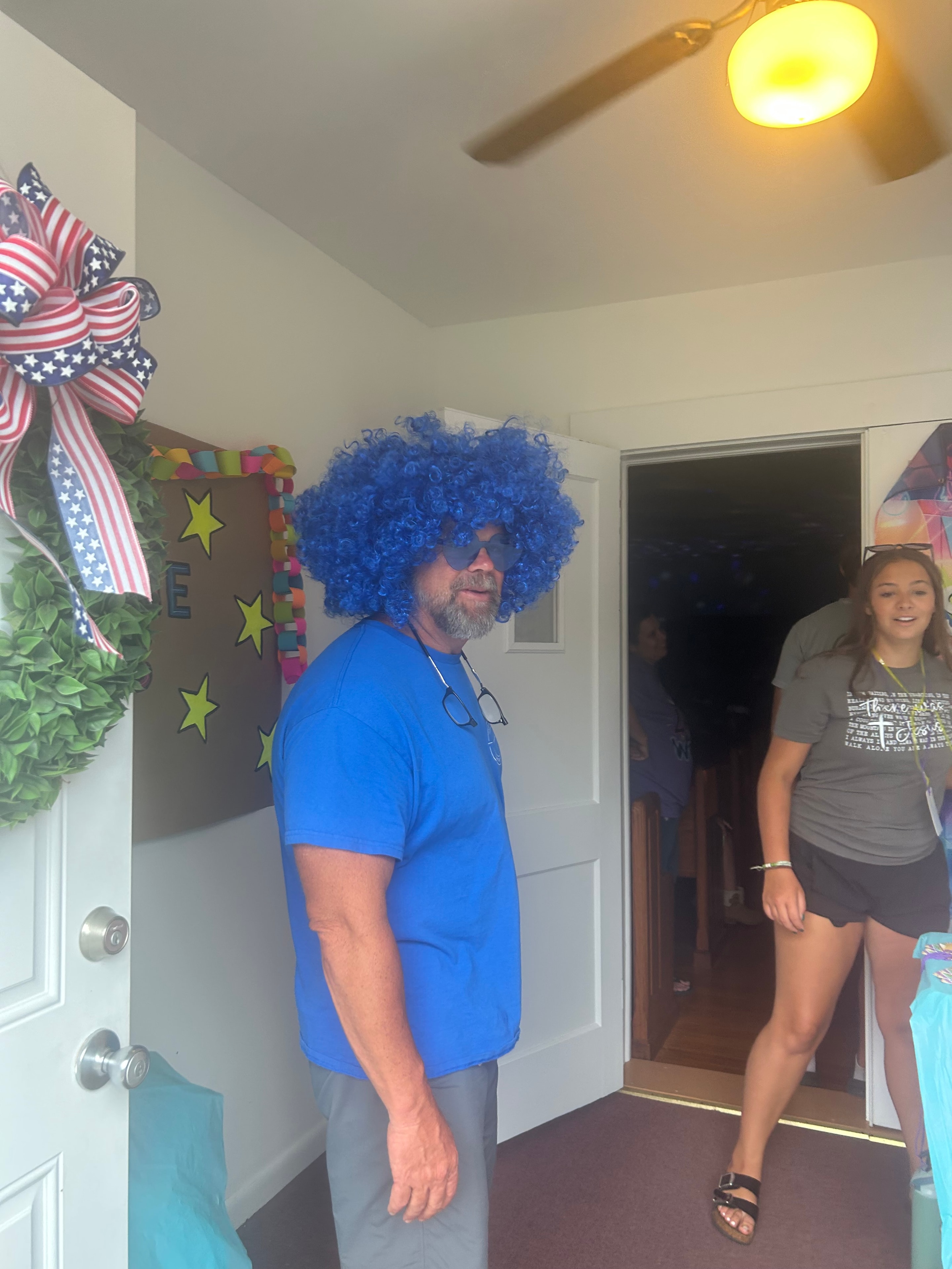 VBS volunteer in blue wig at the registration table