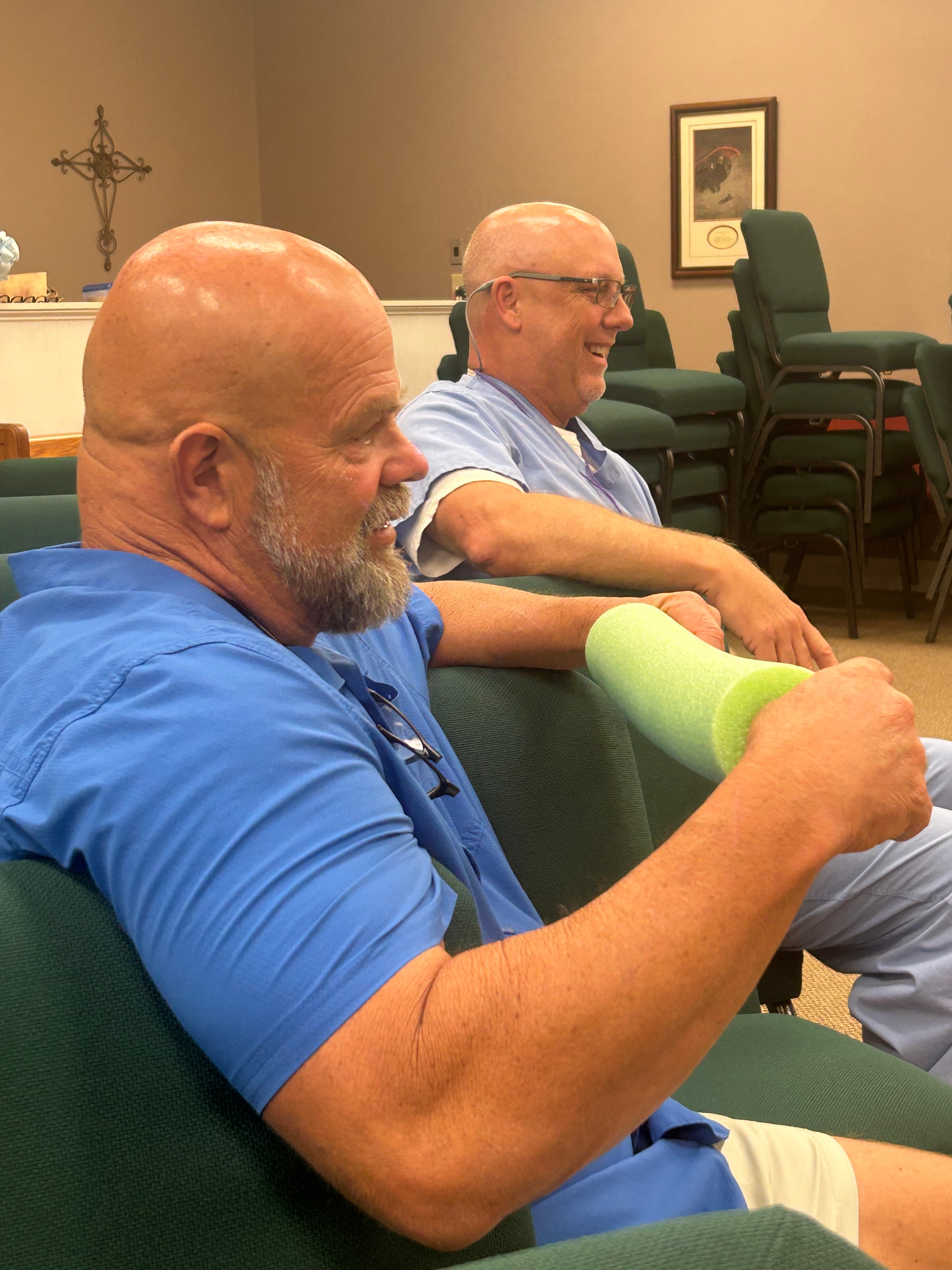 Two men sitting in church chairs at VBS 2026