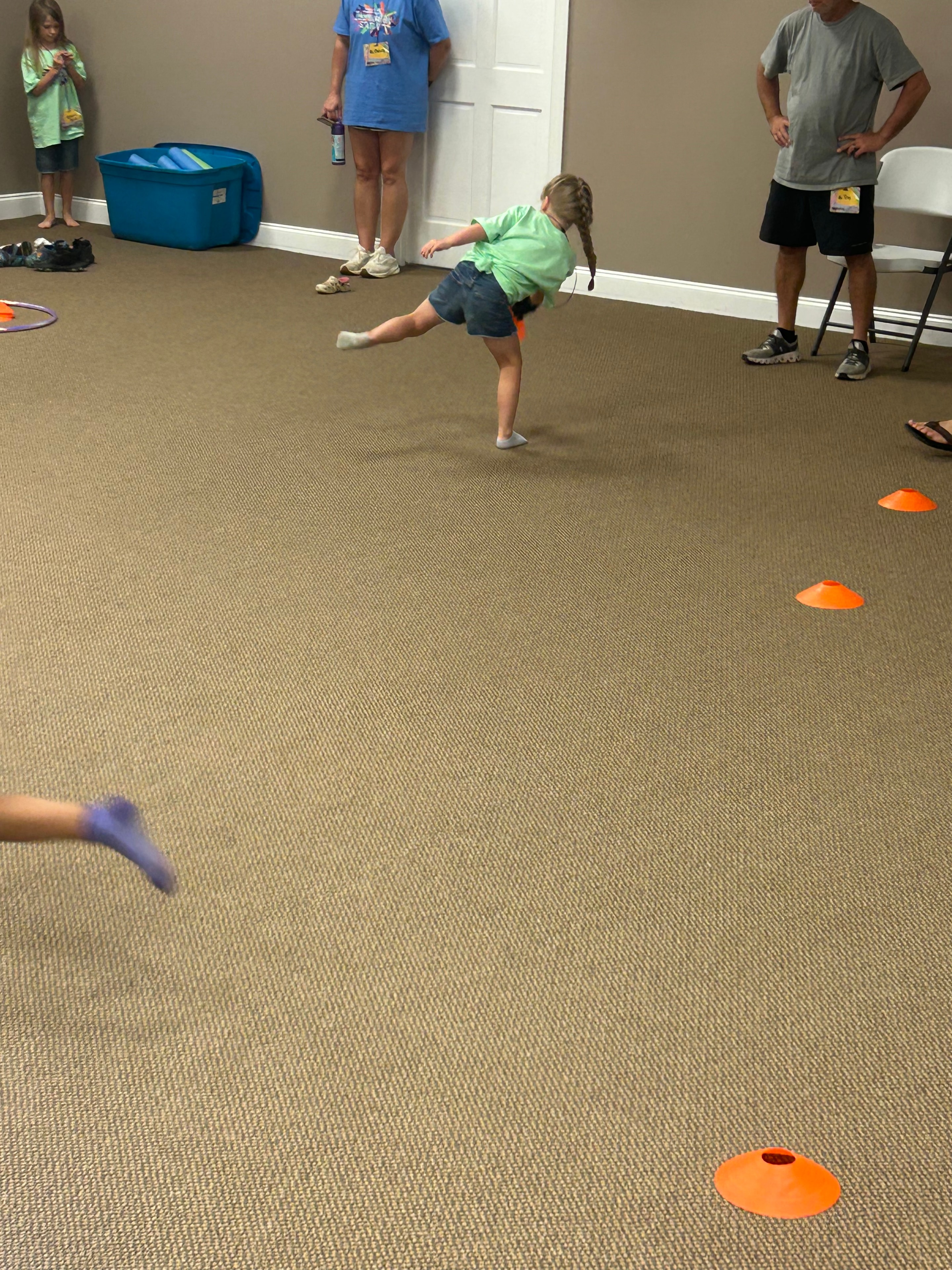 Child doing agility drill between cones indoors at VBS 2026